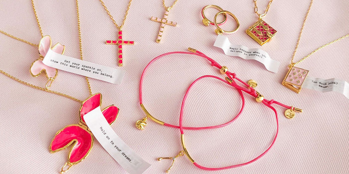 A lot of blush and pink jewelry pieces with barbie fortunes over a pink background